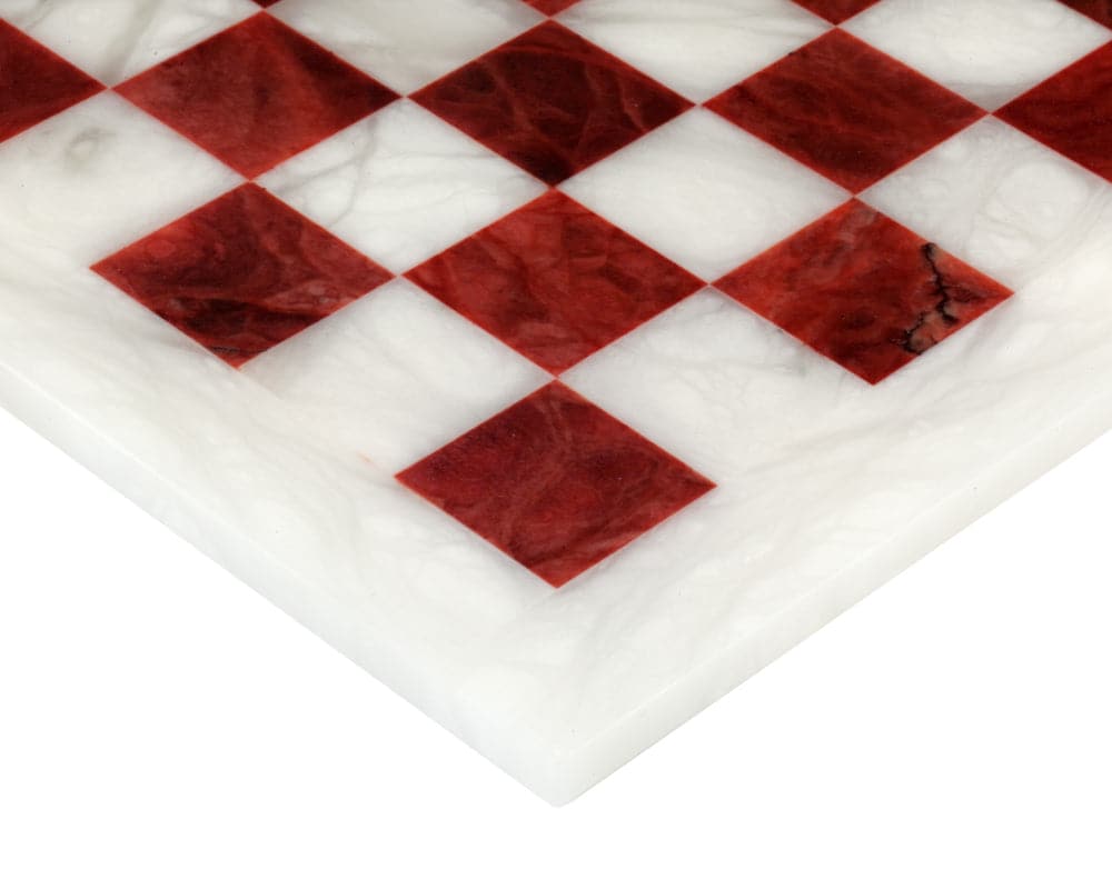 Close-up of red and white alabaster chess board from Italy, showing natural textures and polished mirror finish.