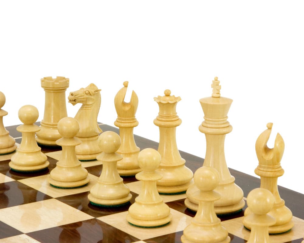 Sandringham Series Ebony Staunton Chess Pieces on a chess board, featuring a 4-inch king, weighted and felted anjan wood pieces, with additional queens.