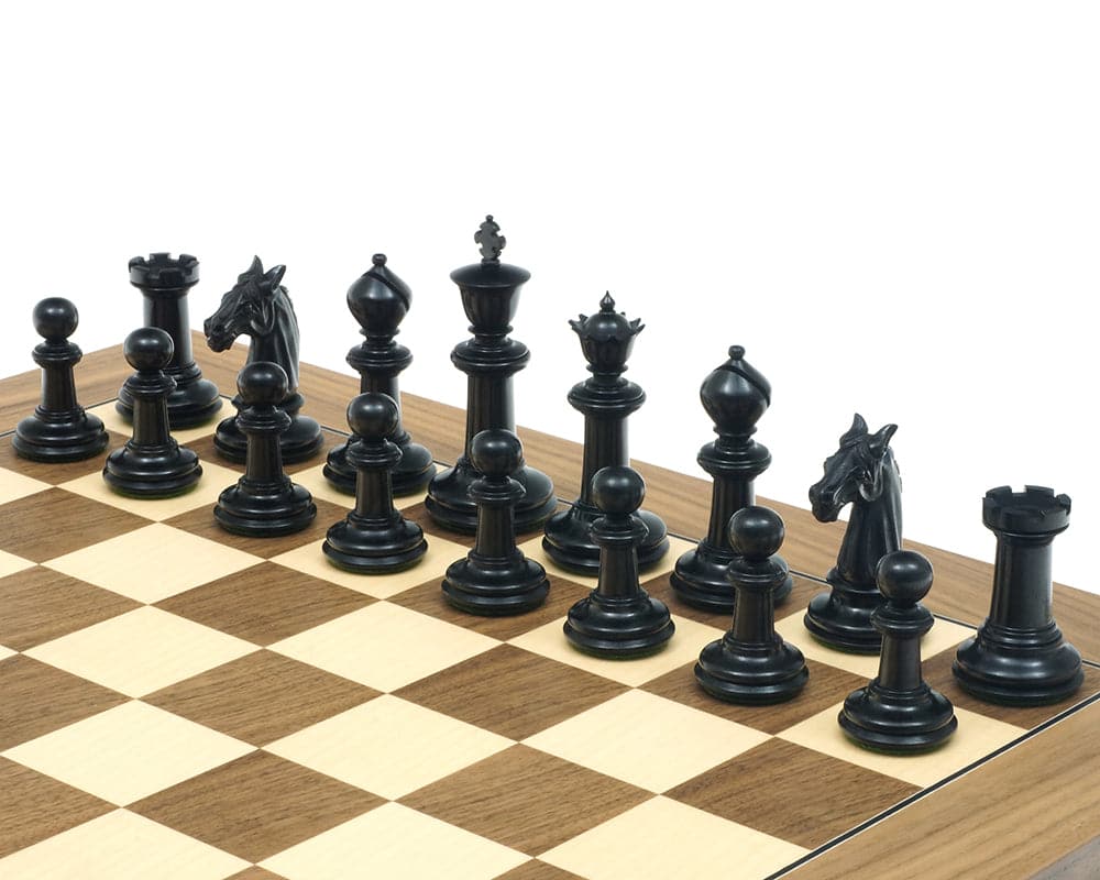 Traditional Staunton ebony chessmen set up on a wooden chessboard, featuring intricately carved, luxurious pieces in solid ebony and boxwood.