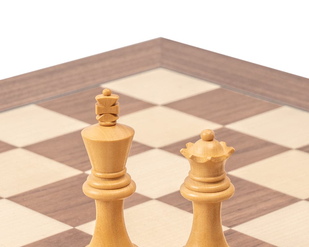 Wooden chess king and queen on a chessboard with light and dark squares