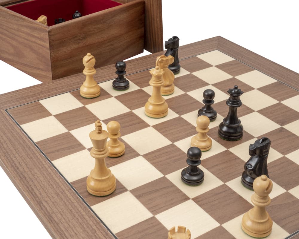 The Levisham 3.5 Inch Ebonised Boxwood Chessmen on a chessboard with a wooden storage box