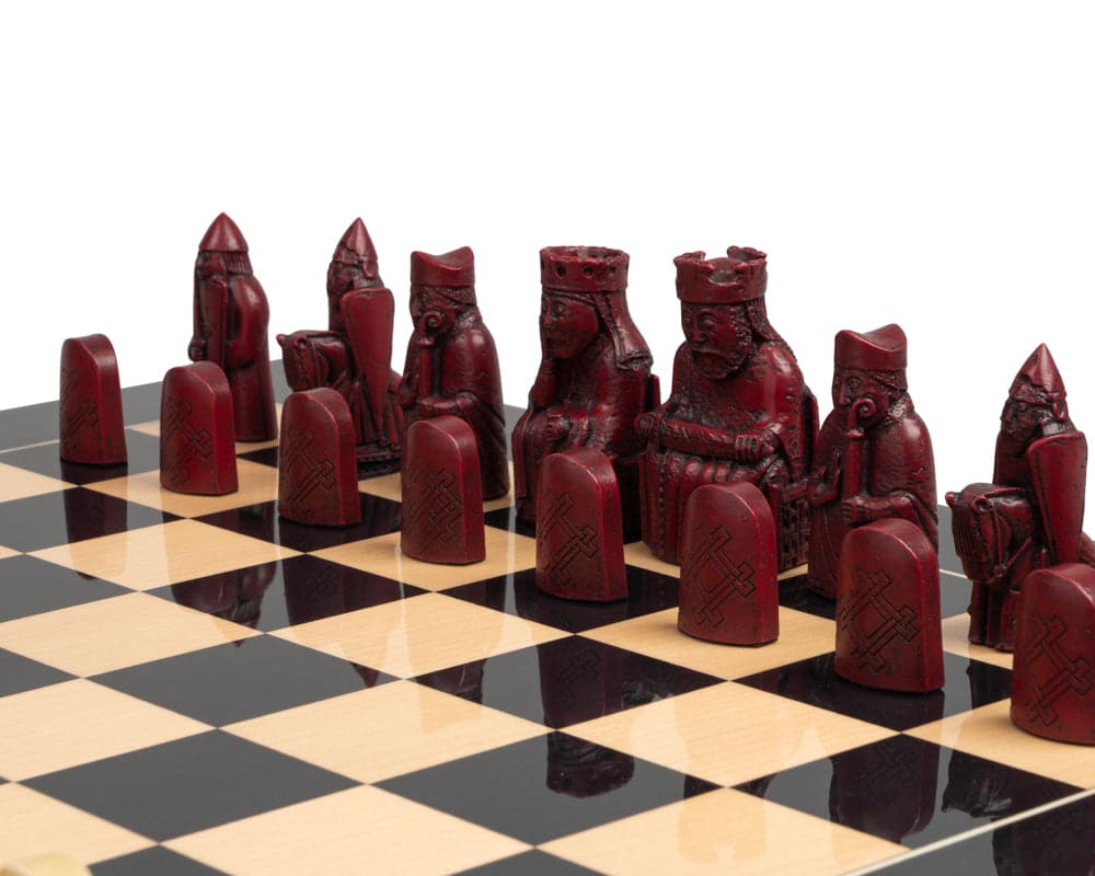 The Isle of Lewis black and red chess set featuring detailed red chessmen on a black and cream chessboard.