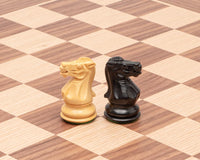 Highclere Ebony and Walnut Traditional Chess Set knights on walnut and maple chessboard, showcasing detailed craftsmanship and classic design