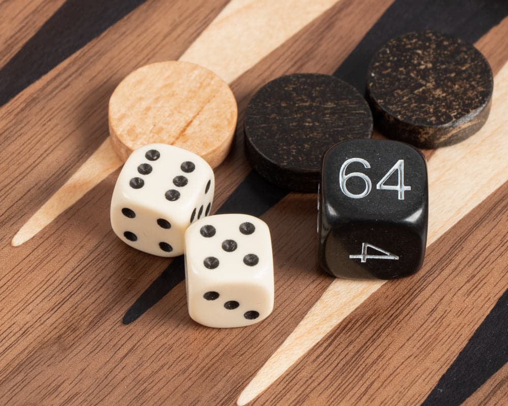 Close-up of backgammon pieces and dice on an American walnut travel-size backgammon and chess combination set.